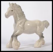 A Beswick ceramic figurine of a shire horse in a white and grey dappled colourway with gloss finish.