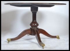 A 19th century Regency mahogany large tilt top breakfast table - loo dining table being raised on