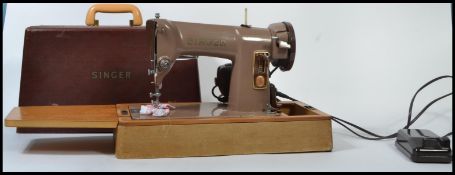 A cased mid 20th century Singer sewing machine, converted to electric together with a metamorphic