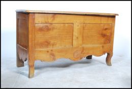A 19th century French fruitwood coffer chest being raised on shaped serpentine legs with carved