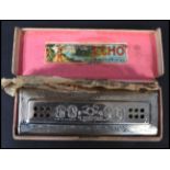 A Hohner Echo harmonica retaining original box and packaging instructions to the inner.