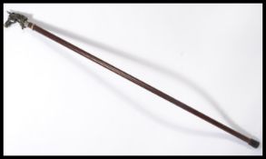 A vintage 20th century walking stick cane having a tapering wooden shaft with silver white metal