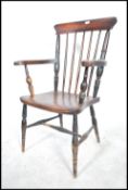 A Victorian beech and elm windsor armchair raised on turned legs united by stretchers, saddle