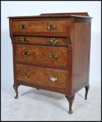 An early 20th century walnut chest of four graduating drawers with swag brass handles and back