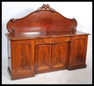 A Victorian mahogany breakfront sideboard dresser being raised on a plinth base with a series of 3