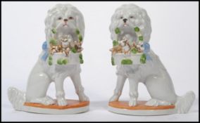 A pair of Staffordshire type porcelain figurines depicting Poodles ( dogs ). Each with white glaze