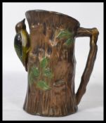 A vintage early 20th century studio pottery ewer water jug decorated with an embossed with a Green