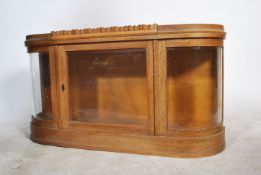 An early 20th century wall mounted oak and bow fronted glass hanging display cabinet. Bow glass