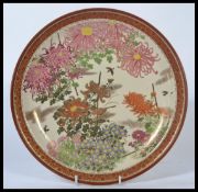 An early 20th century Japanese satsuma pattern charge hand painted with floral sprays , birds and