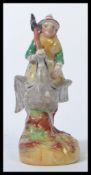 A late 19th Century Staffordshire figure group 'Mother Goose' the mound base painted in green and