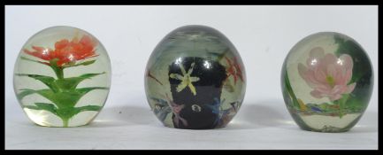 A group of three Nailsea glass 19th century Victorian paperweight glass dumps having inset floral
