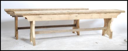 A pair of Ecclesiastical rustic pine refectory pig benches. Each with shaped single plank tops of