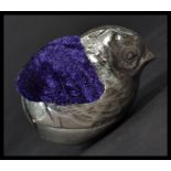 A sterling silver pin cushion in the form of a chick with purple cushion to back , in the manner