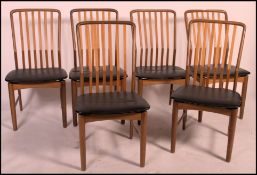A set of Danish mid century 1950's teak dining chairs in the manner of AJ Milne. Raised on turned