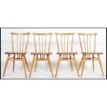 A set of 4 mid century retro Ercol dining chairs being raised on turned legs with stretchers, saddle