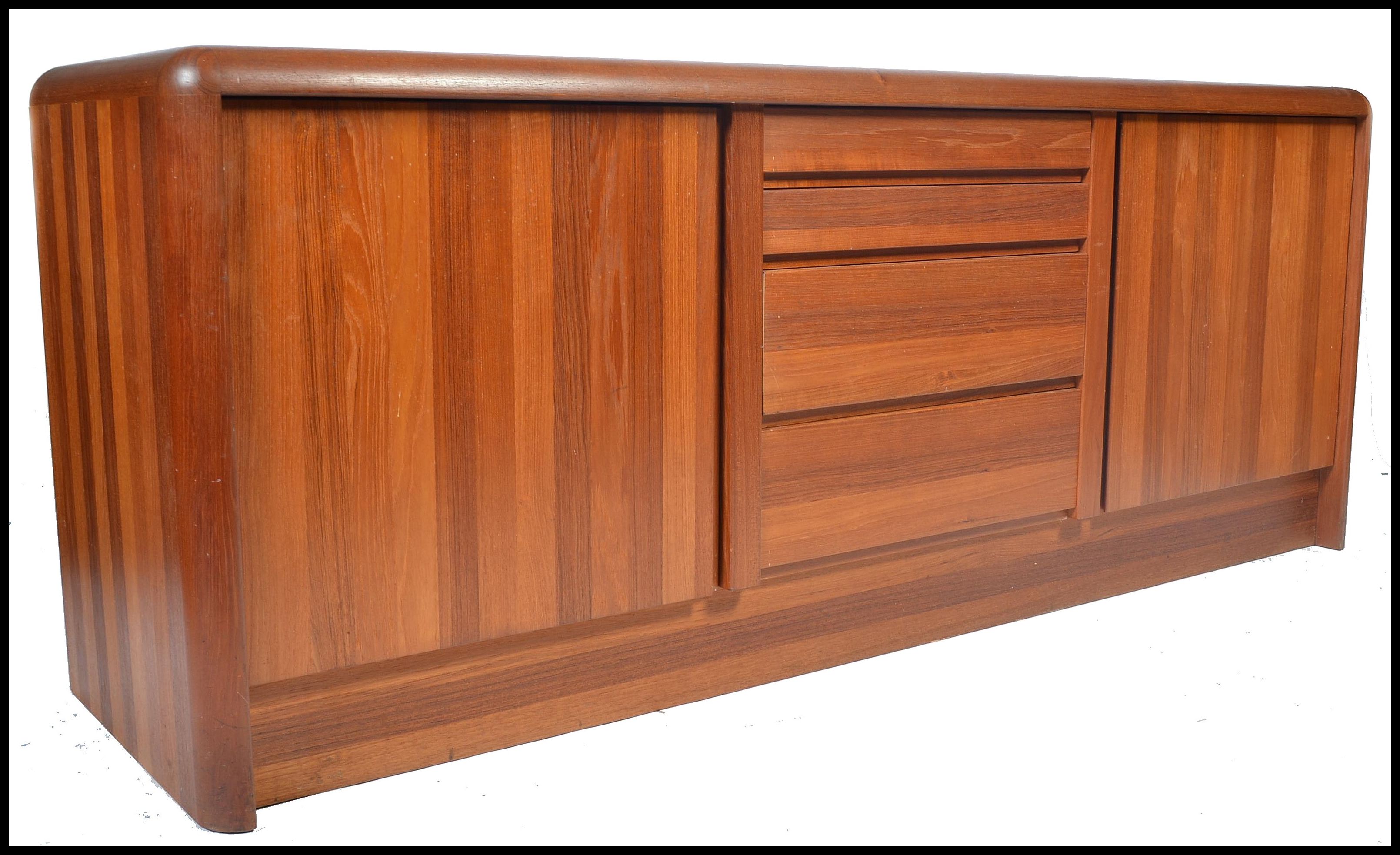 A 20th century Danish sideboard of low form and heavy solid teak construction by Ejvind Johansen