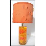 A retro vintage mid 20th century Shatterline amber type resin lamp base in orange having a