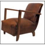 An early 20th century leather club armchair. Raised on block feet having an overstuffed seat and