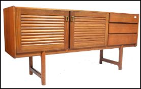 A 1970's McIntosh of Kirkaldy teak wood sideboard being raised on shaped legs with louvre doors