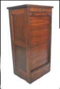 An early 20th century tambour fronted filing cabinet having a locking front that slides down to