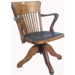 An early 20th century Industrial office swivel chair / desk armchair being raised on quadruped