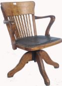 An early 20th century Industrial office swivel chair / desk armchair being raised on quadruped