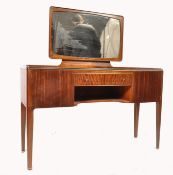 A 1970's teak wood space age dressing table being raised on tapering squared legs with a series of