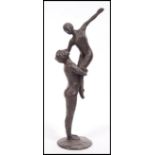 A vintage 20th century bronze statue figurine group of a dancing couple raised on a circular base.