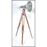 An exceptional large industrial polished steel and wooden tripod theatre light. The stunning