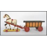 An early 20th century decorative children's wooden horse and cart toy. The painted horse on yellow