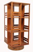 An unusual mid century teak wood revolving bookcase of large upright form with slatted body raised