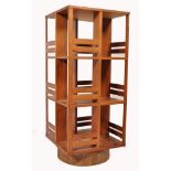 An unusual mid century teak wood revolving bookcase of large upright form with slatted body raised