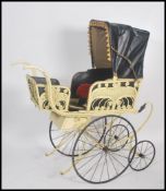 An impressive and large wicker and wrought metal oversized Victorian pram. The large wheels with