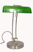 A 20th century retro bankers lamp having a brushed metal twin sweeping arm attached to a terraced