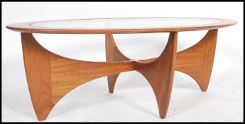 A retro teak wood atomic ' Astro ' oval coffee table by G Plan, having a drop centre glass panel,