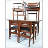A 1970's White & Newton teak wood dining room table and chairs. Raised on squared legs with