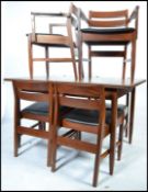 A 1970's White & Newton teak wood dining room table and chairs. Raised on squared legs with