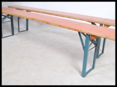 A pair of mid century Industrial factory work benches. Each of panelled wood with folding metal legs