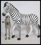 A stunning life-size resin painted grand scale adult female Zebra sculpture together with a Zebra