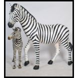 A stunning life-size resin painted grand scale adult female Zebra sculpture together with a Zebra