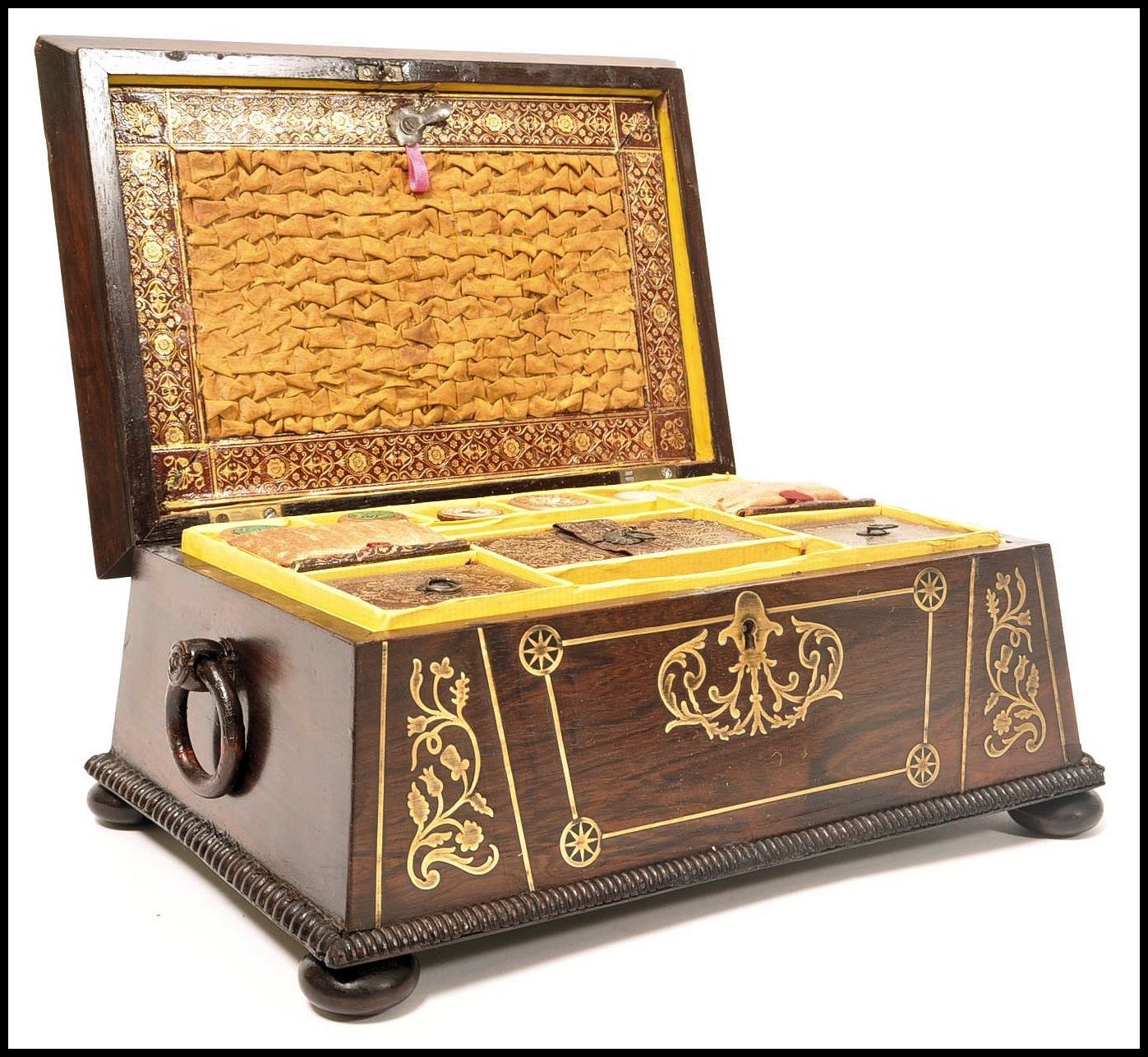 A Regency rosewood brass inlaid work box raised on bun feet with gadrooned edges. Loop handles to