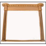 A 19th century gilt wood overmantel mirror of large form having bow corner multiple turned pilasters