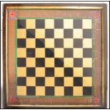 A 19th century eglomise painted chess board gilt in and ebony chequer with greek banded decoration