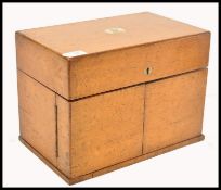 A 19th century Victorian golden oak three decanter Tantalus box having brass monogram to lid. The