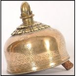 A 19th century Indian brass cow bell having chased ring decoration. The bell of traditional shape