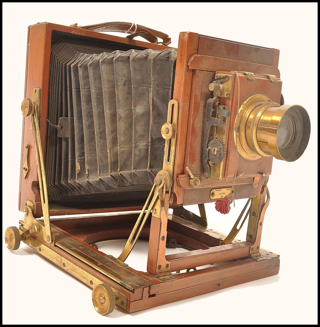 An early 20th century The Victo plate bellows camera having a mahogany case with brass mounts. Brass