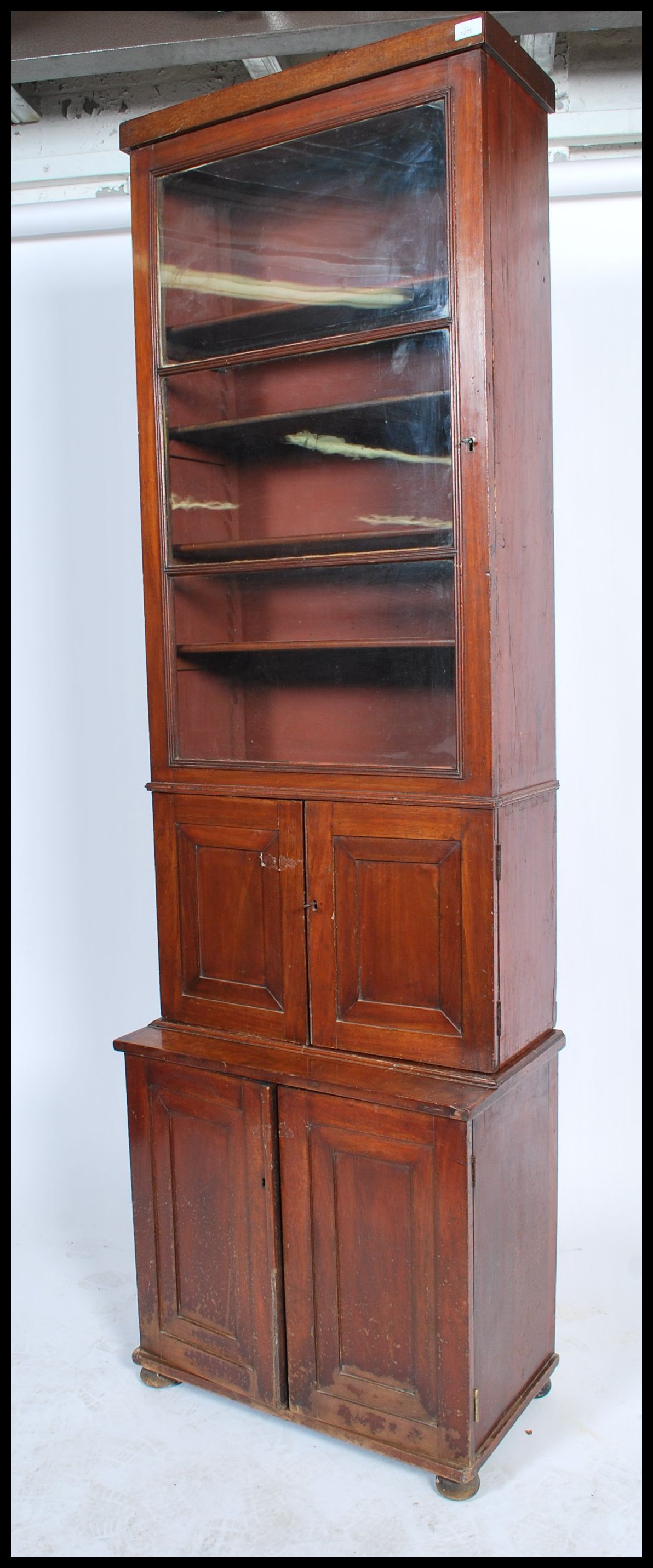 A 19th century mahogany bookcase cupboard of slim