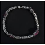 A sterling silver and ruby set cz line bracelet wi