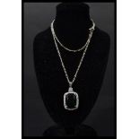 A silver CZ and faux emerald necklace pendant set