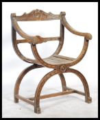 A 20th century carved oak / beech wood Savonarola throne chair having shaped base with carved back